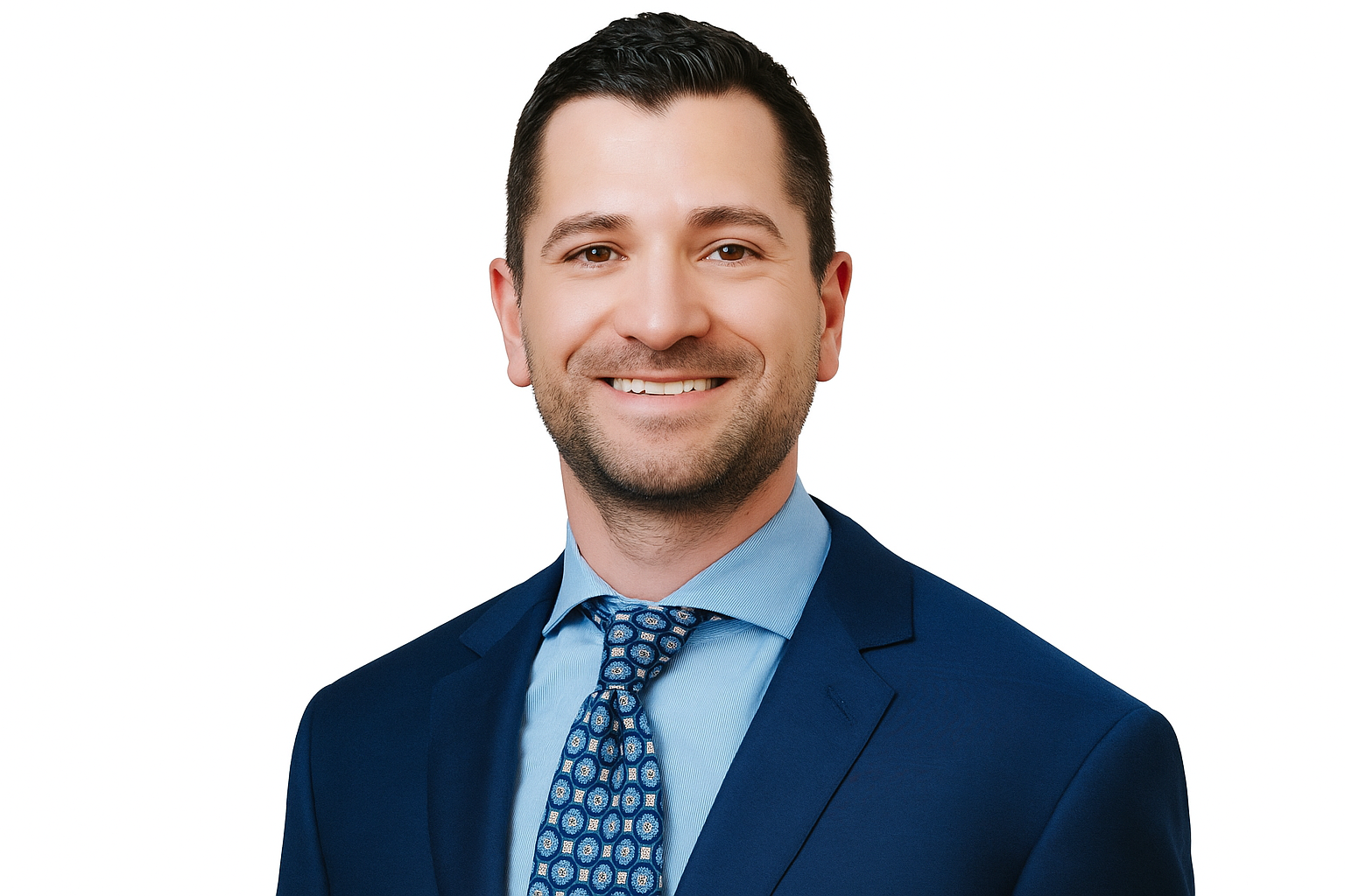 Man in a blue suit and patterned tie smiling at the camera against a white background.