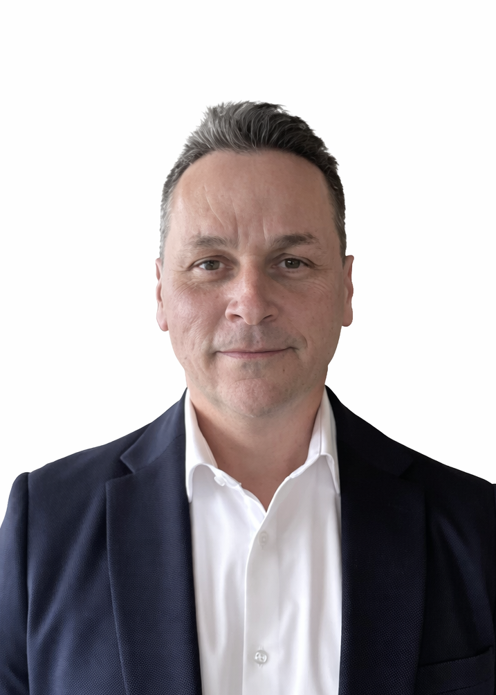 A man with short dark hair wearing a dark suit jacket and white shirt, facing the camera against a plain white background.