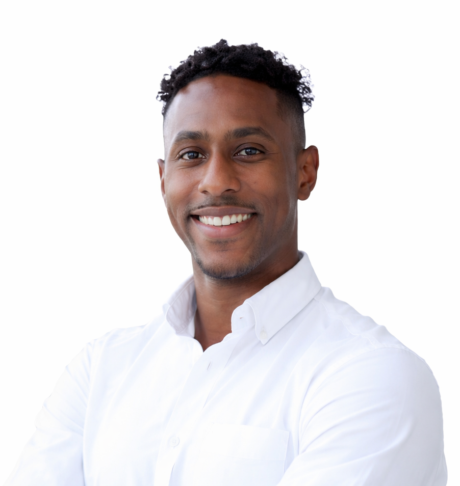 A man with short curly hair and a trimmed beard, wearing a white button-up shirt, stands smiling with his arms crossed against a plain white background—reflecting the confident professionalism of the Extendicare leadership team.