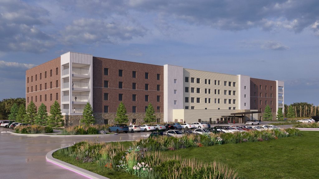 A four-story modern building for the future with a large parking lot in front, surrounded by landscaped greenery and a partly cloudy sky overhead.